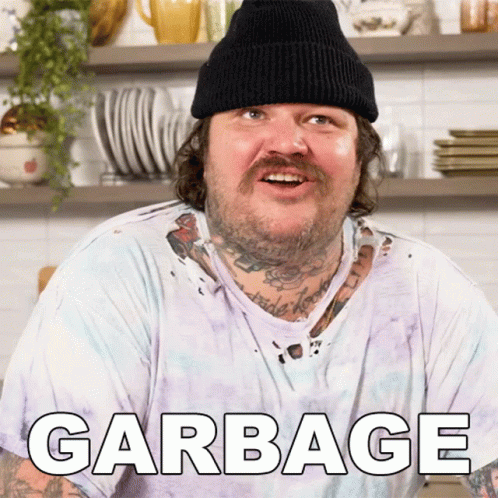 A Man Wearing A Beanie And A White T-Shirt With Garbage Written On It GIF