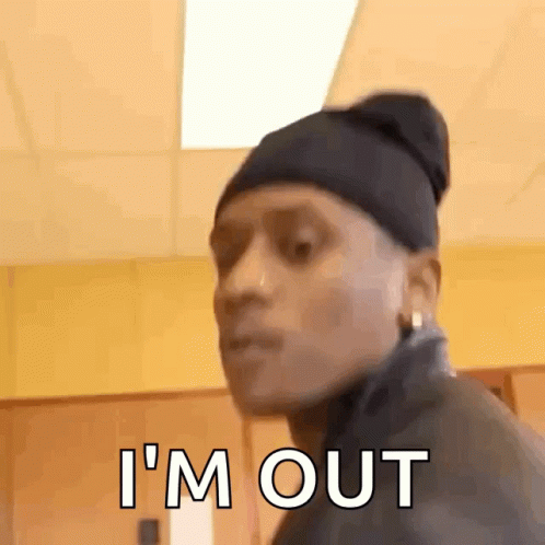 A Man Wearing A Beanie And Earrings Is Standing In A Room And Says I 'M Out . GIF