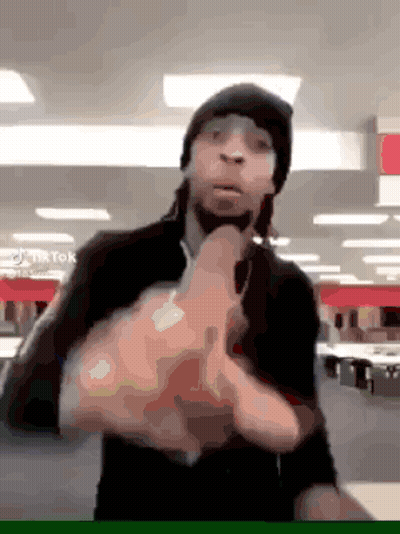 A Man Wearing A Beanie And Sunglasses Is Giving The Middle Finger GIF
