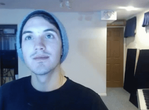 A Man Wearing A Beanie Looks At The Camera GIF