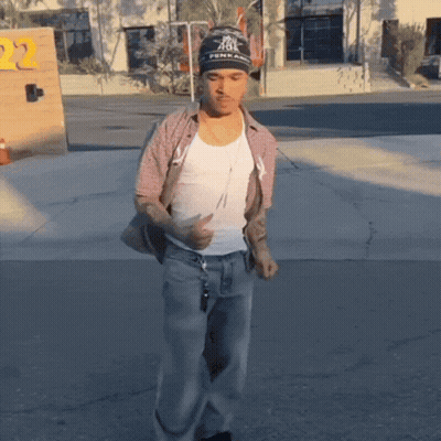 A Man Wearing A Beanie That Says Fenix On It Is Walking Down The Street GIF