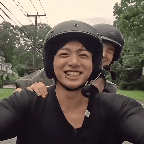A Man Wearing A Bell Helmet Smiles With Another Man GIF