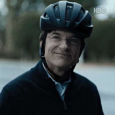 A Man Wearing A Bicycle Helmet And Glasses Is Smiling For The Camera With The Hbo Logo In The Background GIF
