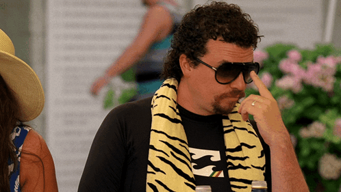A Man Wearing A Billabong Shirt And A Tiger Print Scarf GIF