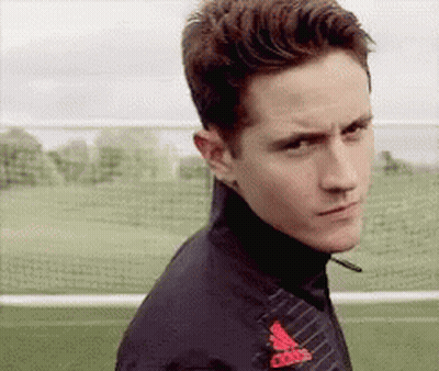 A Man Wearing A Black Adidas Jacket Is Standing On A Soccer Field GIF