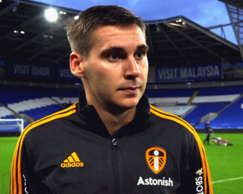 A Man Wearing A Black Adidas Jacket With Yellow Stripes GIF