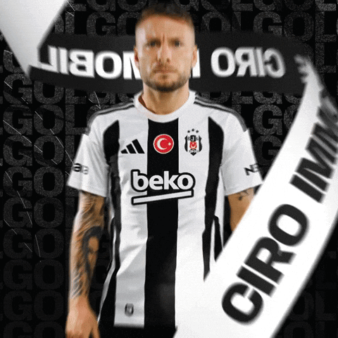 A Man Wearing A Black And White Beko Shirt Stands In Front Of A Black Background GIF