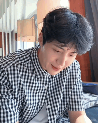 A Man Wearing A Black And White Checkered Shirt Is Smiling GIF