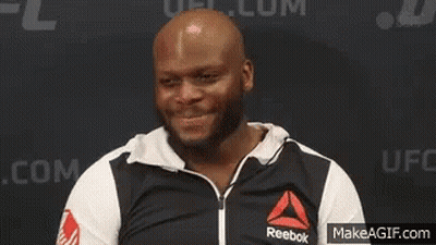 A Man Wearing A Black And White Reebok Jacket Is Standing In Front Of A Wall . GIF
