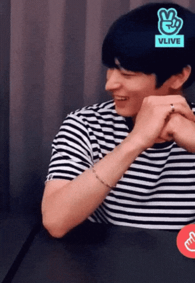 A Man Wearing A Black And White Striped Shirt With A Vlive Logo On His Head GIF