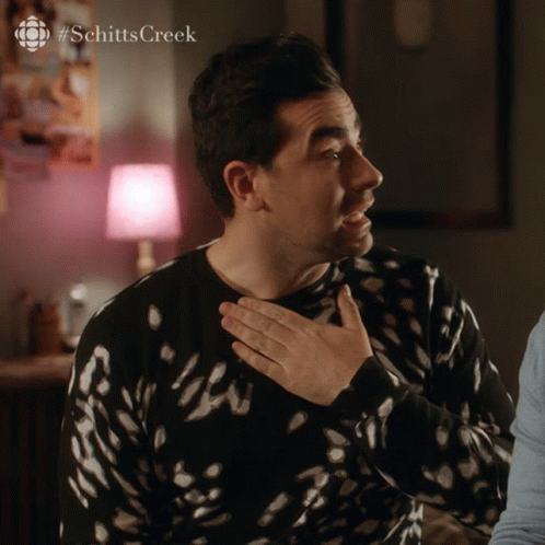 A Man Wearing A Black And White Sweater With #Schitts Creek Written On The Bottom GIF