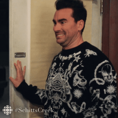 A Man Wearing A Black And White Sweater With The Word Schitts Creek On The Bottom GIF