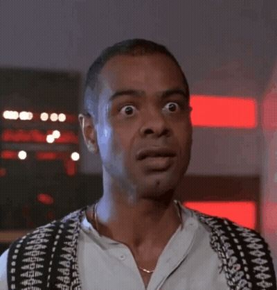 A Man Wearing A Black And White Vest Looks Surprised GIF