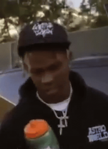 A Man Wearing A Black Astroworld Shirt Holds A Bottle GIF