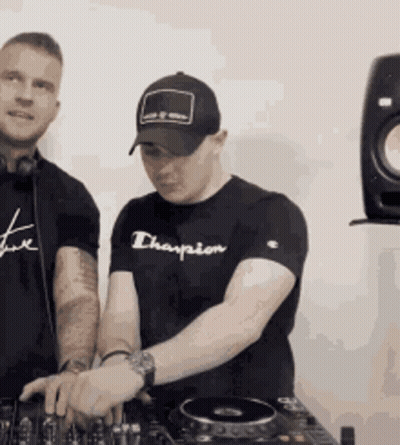 A Man Wearing A Black Champion Shirt Is Playing Music GIF