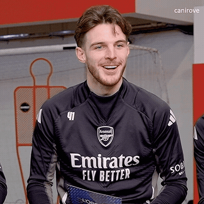 A Man Wearing A Black Emirates Fly Better Jersey Smiles GIF