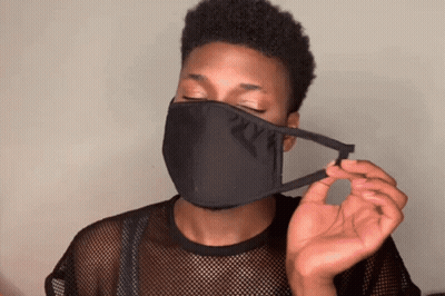 A Man Wearing A Black Face Mask Is Holding A Piece Of Fabric GIF