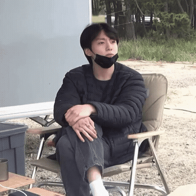 A Man Wearing A Black Face Mask Sits In A Chair GIF