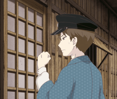 A Man Wearing A Black Hat And A Blue Jacket Stands In Front Of A Wooden Wall GIF