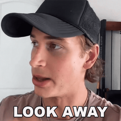 A Man Wearing A Black Hat And A Necklace Says Look Away GIF