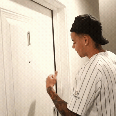 A Man Wearing A Black Hat And A White Striped Shirt With The Word Belt On The Front GIF