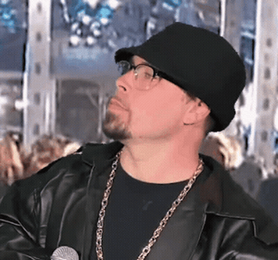 A Man Wearing A Black Hat And Glasses Holds A Microphone GIF