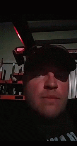 A Man Wearing A Black Hat Is Blowing A Kiss At The Camera GIF