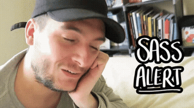 A Man Wearing A Black Hat Is Talking On A Cell Phone With Sass Alert Written On The Bottom GIF