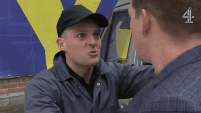 A Man Wearing A Black Hat Is Talking To Another Man In Front Of A Van That Says 4 GIF