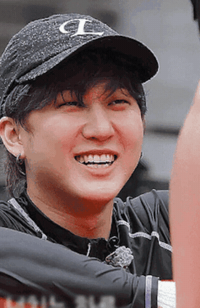 A Man Wearing A Black Hat With The Letter L On It Smiles GIF