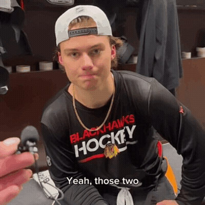 A Man Wearing A Black Hawks Hockey Shirt GIF