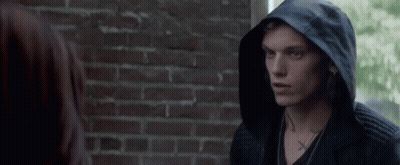 A Man Wearing A Black Hooded Jacket Has A Cross Tattoo On His Neck GIF