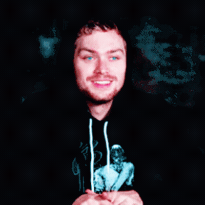 A Man Wearing A Black Hoodie With A Picture Of A Woman On It Is Smiling GIF