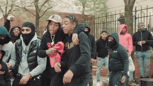 A Man Wearing A Black Hoodie With The Word Kill On It Stands In A Crowd Of People GIF