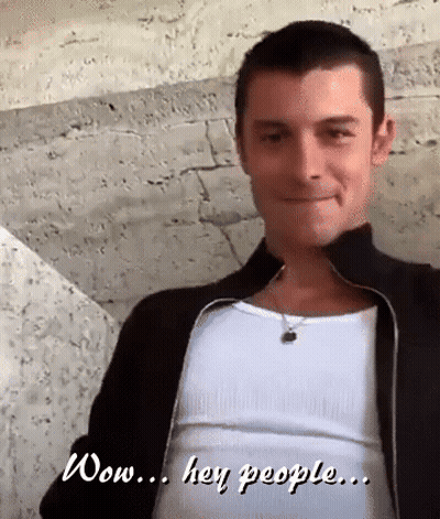 A Man Wearing A Black Jacket And A White Tank Top Says " Wow Hey People " GIF