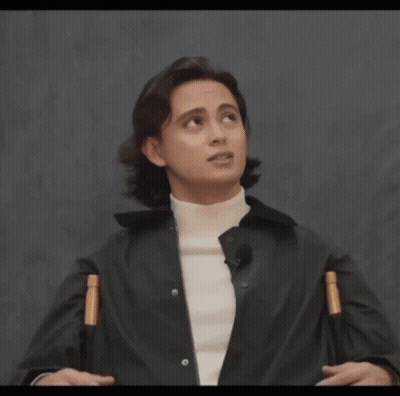 A Man Wearing A Black Jacket And A White Turtleneck Looks Up At The Sky GIF