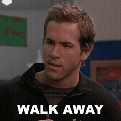 A Man Wearing A Black Jacket Stands In Front Of A Sign That Says " Walk Away " GIF