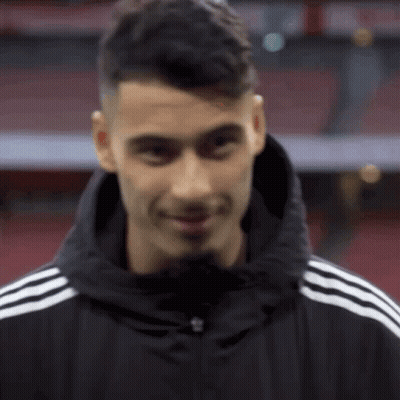 A Man Wearing A Black Jacket With White Stripes On The Sleeves GIF
