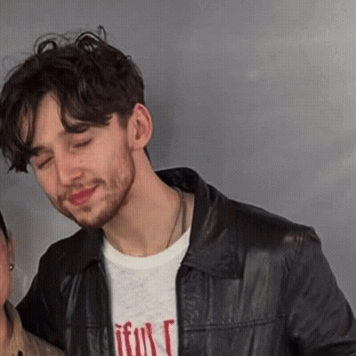 A Man Wearing A Black Leather Jacket And A T-Shirt That Says " Faithful " GIF
