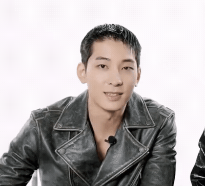 A Man Wearing A Black Leather Jacket Is Smiling GIF