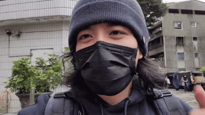 A Man Wearing A Black Mask And A Beanie Is Looking At The Camera GIF