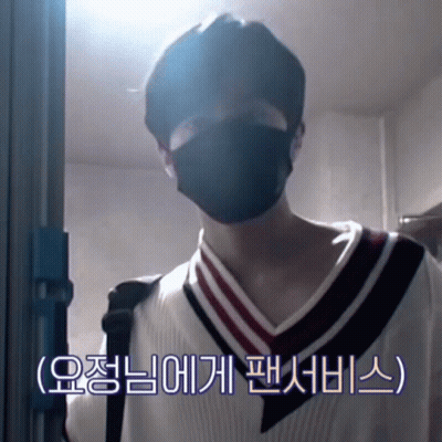 A Man Wearing A Black Mask Is Standing In Front Of A Blue Door GIF