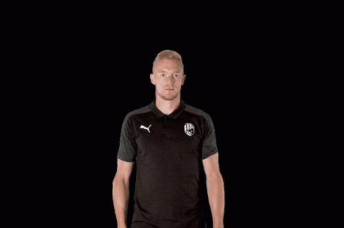 A Man Wearing A Black Polo Shirt With A Puma Logo On It GIF