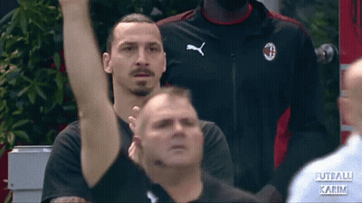 A Man Wearing A Black Puma Shirt Stands In A Crowd GIF