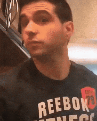 A Man Wearing A Black Reebok T-Shirt Is Making A Funny Face GIF