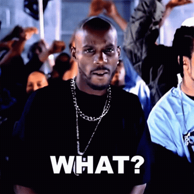 A Man Wearing A Black Shirt And A Chain Says What GIF