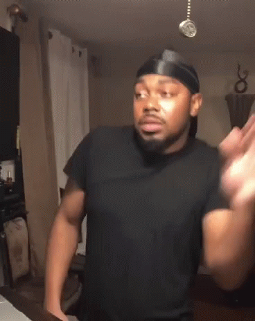 A Man Wearing A Black Shirt And A Headband Is Standing In A Kitchen GIF