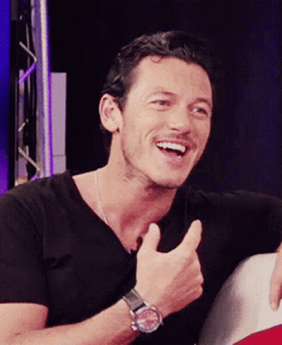 A Man Wearing A Black Shirt And A Watch Giving A Thumbs Up GIF
