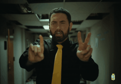 A Man Wearing A Black Shirt And A Yellow Tie Has A Carton Of Minute Maid On His Shirt GIF