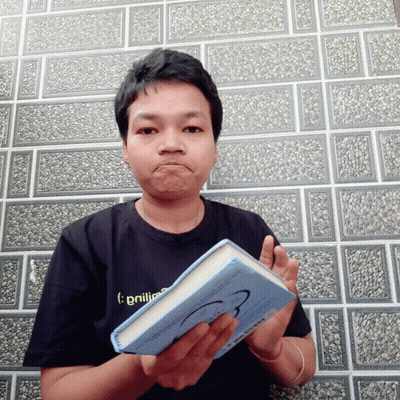 A Man Wearing A Black Shirt That Says ' Brilliance ' On It Holds A Blue Book GIF
